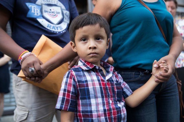 Rosayra Pablo Cruz, right, holds her sons 5-year-old Fernando, center, and 15-year-old Jordy's hands as she speaks to reporters outside the Cayuga Center, in New York in July, 2018.